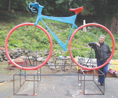 Jerry Beck, founder and artistic director of the Revolving Museum, shows off the 9 1/2-foot-tall, 12-foot-long bicycle he and a group of students built to promote the upcoming Longsjo Classic.COURTESY REVOLVING MUSEUM
